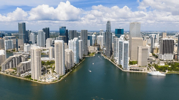 Inversión inmobiliaria en Florida: edificios modernos frente al mar, símbolo de la decisión entre renta vacacional (Airbnb) y alquiler tradicional.